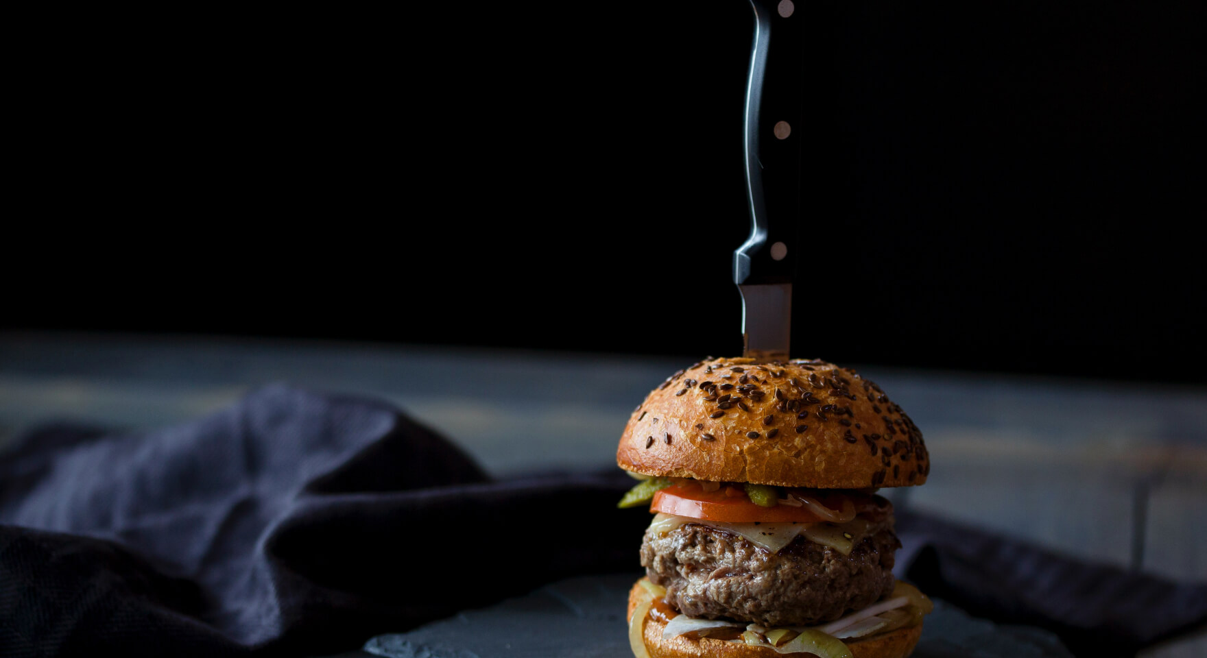 A mouth-watering burger on a plate, representing a menu item easily ordered through a modern bar automation system.