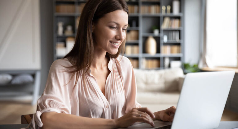 A young accountant focused on a laptop screen displaying an accounting software dashboard